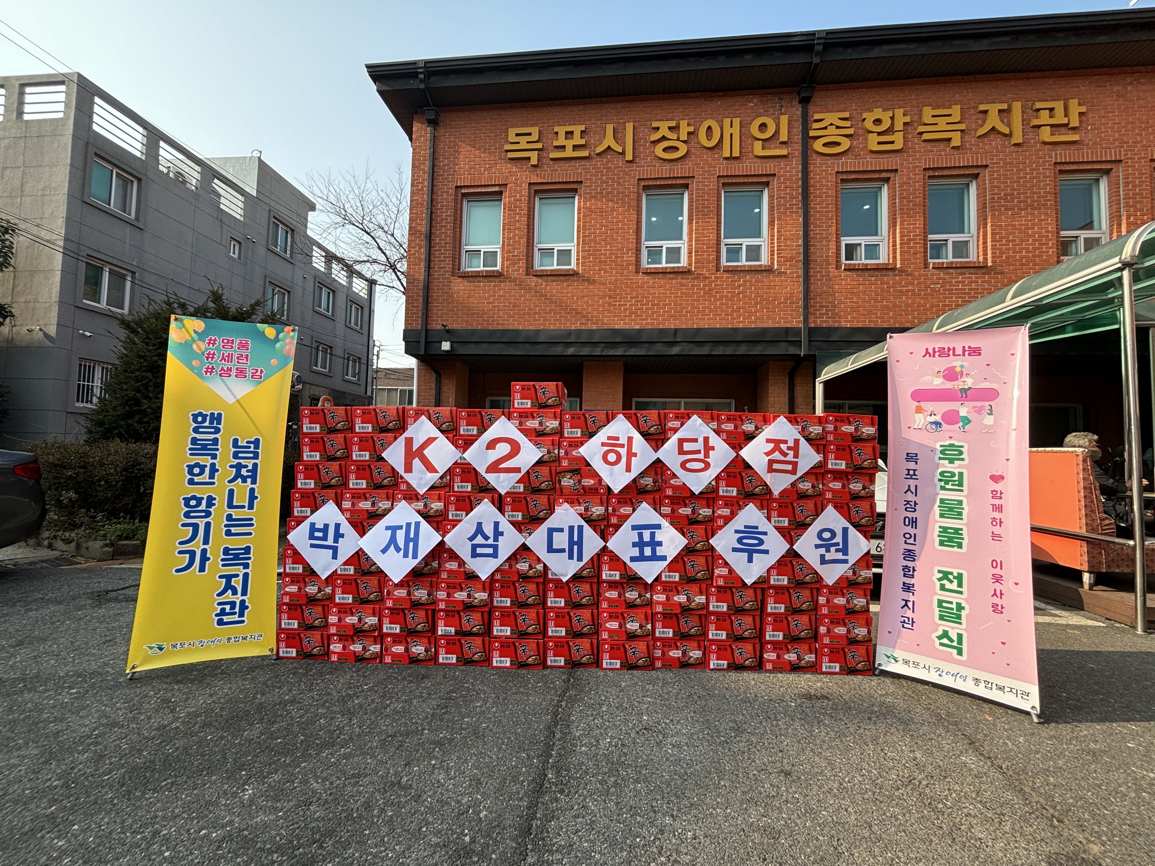 『후원품 전달』 k2 코리아, 사랑의 신라면 100박스 후원.jpg