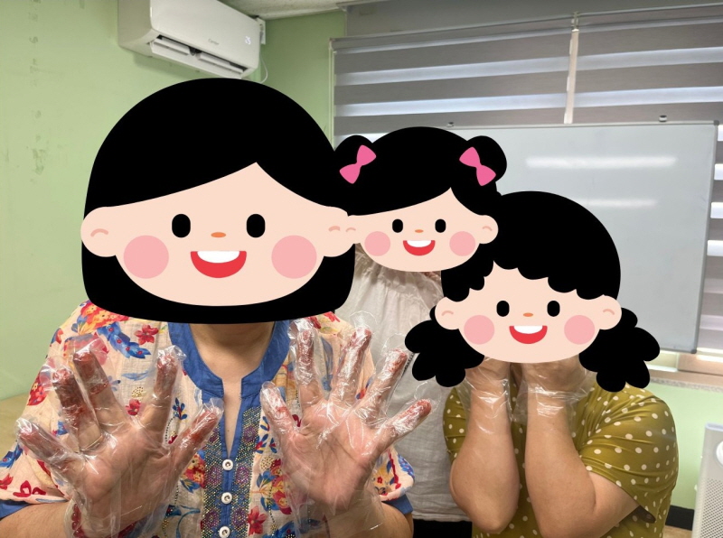 여성장애인교육지원사업 프로그램 활동 모습. 세 사람이 위생 비닐장갑을 끼고 즐겁게 포즈를 취하고 있다. 얼굴은 캐릭터 그림으로 가려져 있으며, 손을 들거나 턱을 괴며 웃는 자세를 하고 있다.