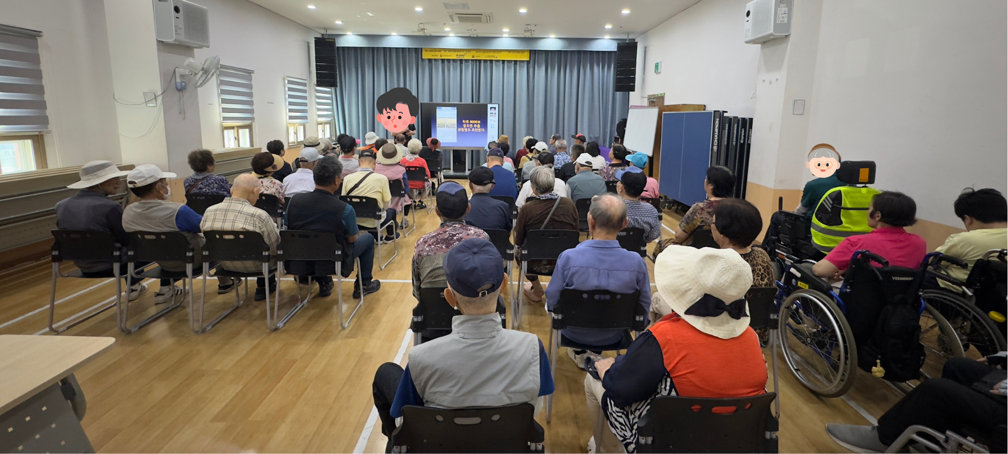 강당 안에 많은 참가자들이 의자에 앉아 강의를 듣고 있으며, 일부는 휠체어를 이용해 참여하고 있습니다. 앞쪽 스크린에는 건강 관련 정보가 표시되고 강사가 설명을 이어가고 있습니다
