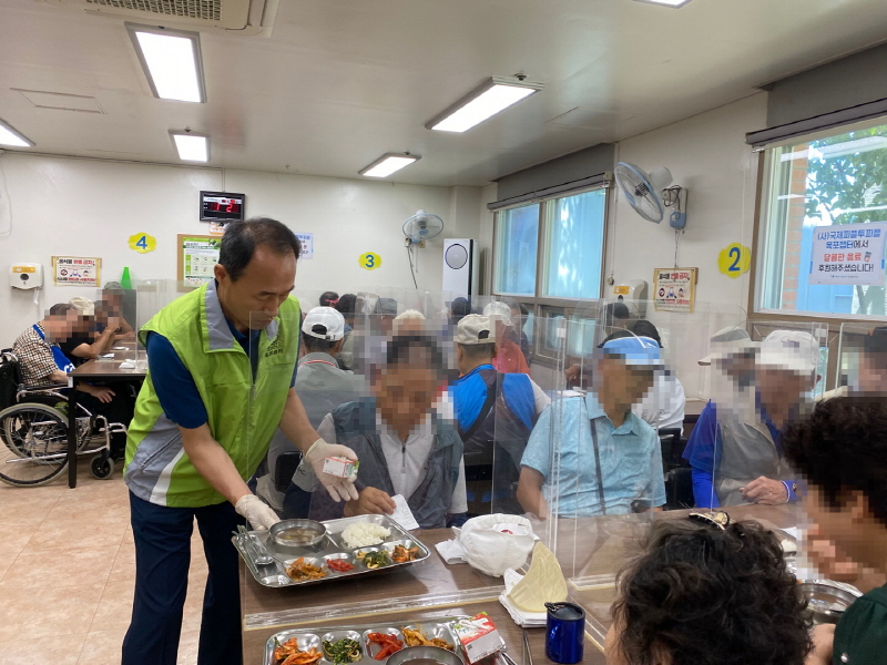 국제피플투피플 목포챕터 남성 봉사자가 장애인에게 밥과 반찬이 담긴 식판을 나누어주는 모습