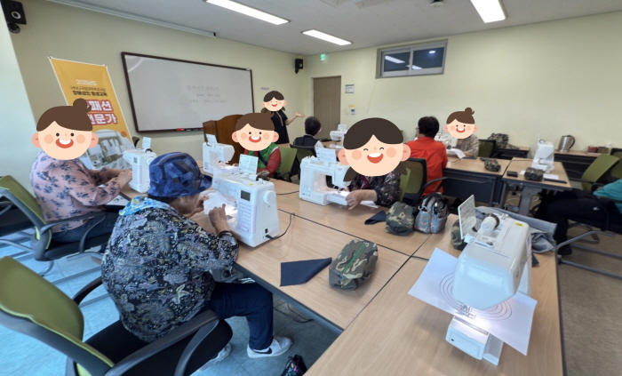 복지관 교육실에서 어르신들이 재봉틀을 사용해 바느질과 재봉을 배우고 있다. 책상 위에 개인 재봉틀이 놓여 있고, 강사의 지도를 받으며 작품을 만드는 모습이다.