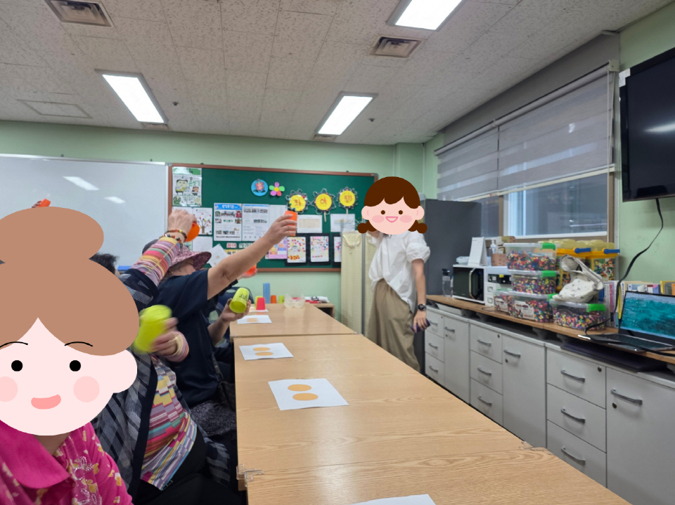 강사가 앞에 서서 설명하고, 참여자들이 자리에서 손을 들며 작은 컵을 활용한 활동에 참여하는 모습