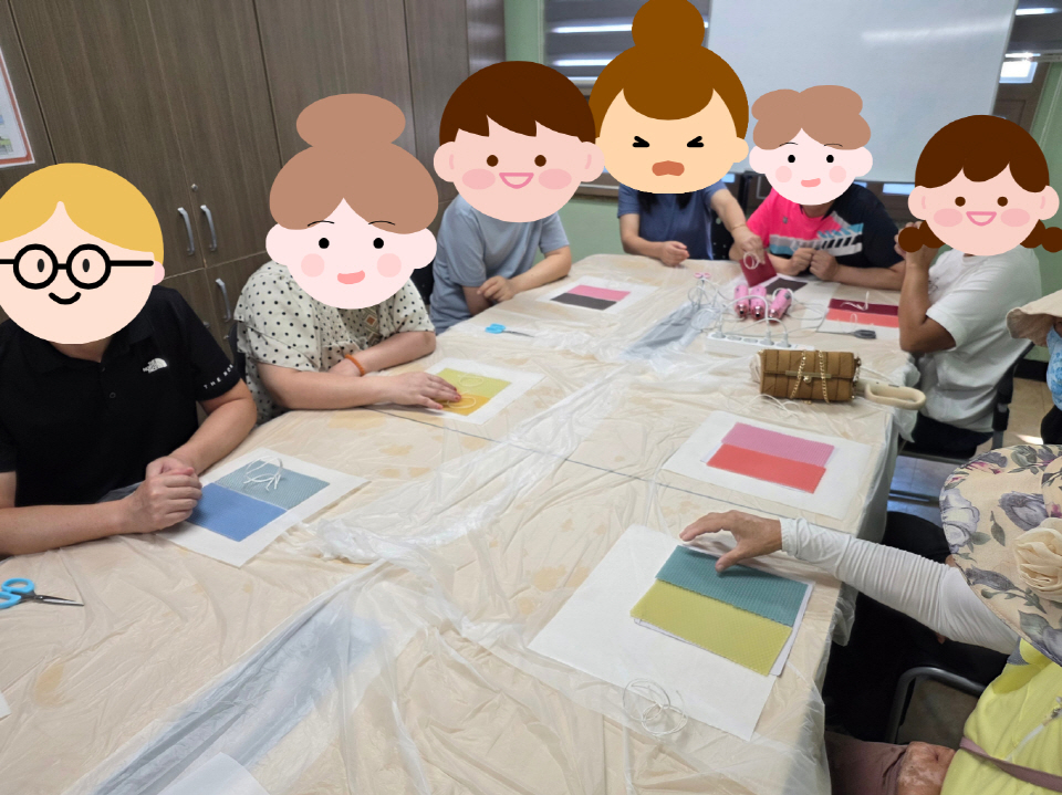 책상 위에 색색의 재료가 놓여 있고 참여자들이 앉아 만들기 활동에 집중하는 모습