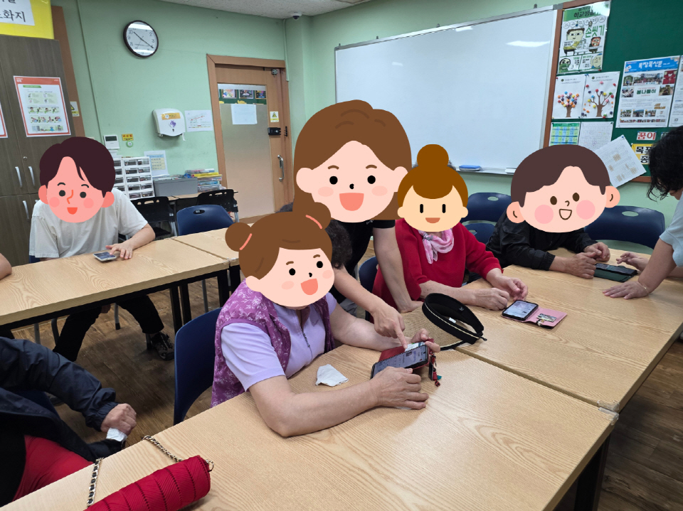 교실 안에서 참여자들이 스마트폰을 들고 사용하는 법을 배우고 있는 모습. 강사가 옆에서 함께 지도하고 있음.