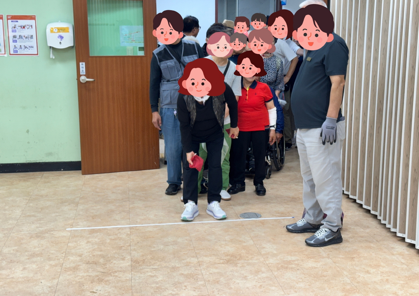 이용고객이 복주머니 모양의 주머니공을 던져 고홀 게임의 목표판 구멍에 넣으려 하고 있으며, 직원이 옆에서 격려하고 대기 중인 이용고객들이 순서를 기다리며 응원하는 모습이다.