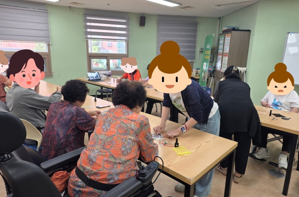 복지관 프로그램실에서 양초공예 활동이 진행되고 있음. 참여자들이 강사의 안내에 따라 향초 재료를 섞고 모양을 만드는 과정에 집중하고 있음. 테이블 위에는 향료, 색소, 도구 등이 놓여 있으며 따뜻한 분위기 속에서 진행되고 있음.