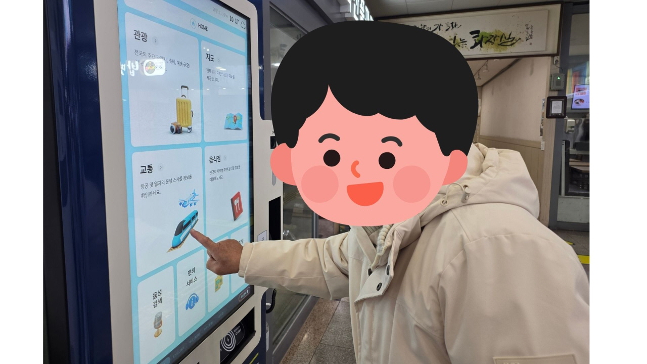 목포역 실내에서 밝은 색 패딩을 입은 이용자가 기차 승차권 발권을 위해 대형 터치 스크린 키오스크 화면을 손가락으로 누르며 조작하고 있고, 화면에는 관광·지도·교통 등 메뉴가 보이는 디지털문해교육 프로그램 활동 장면