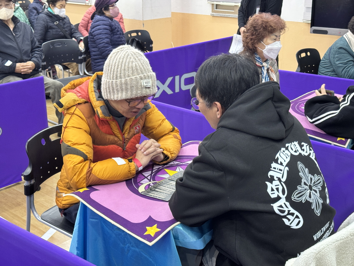 2025 송년감사행사 타로카드 체험활동에서 참가자들이 테이블 위 타로카드를 보며 상담을 받고 있다.