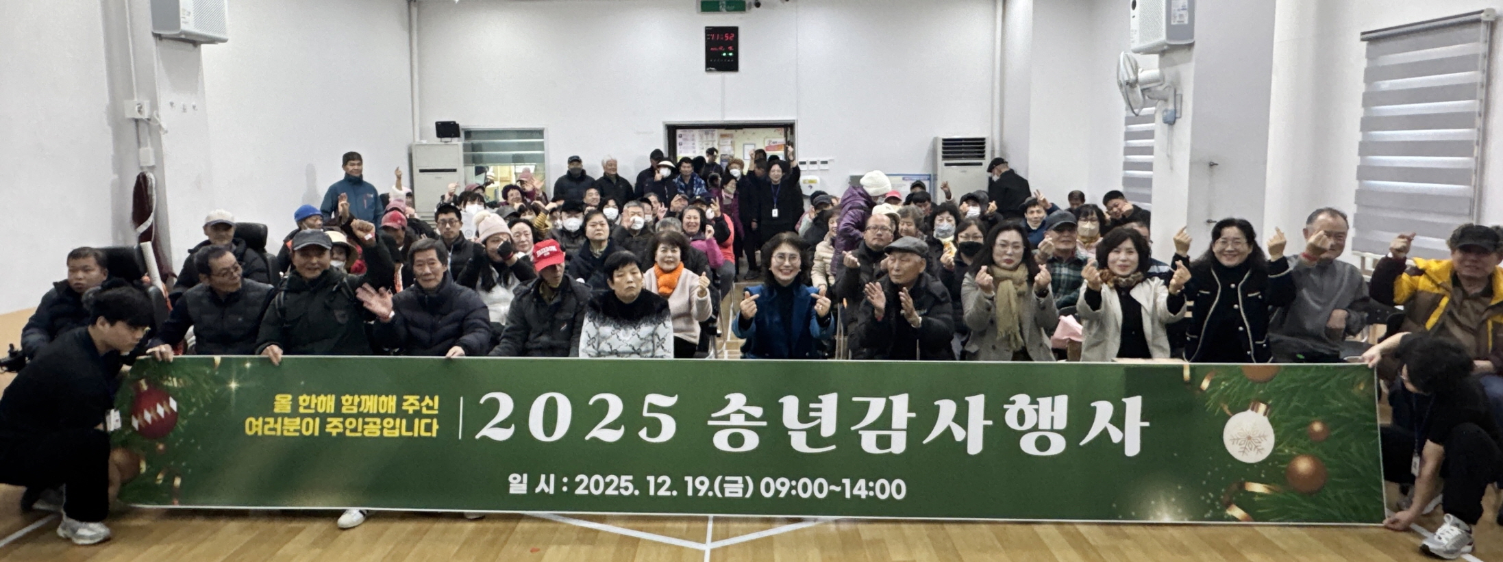 2025 송년감사행사에서 이용고객과 직원들이 행사 현수막을 앞에 두고 단체 기념촬영을 하고 있다.