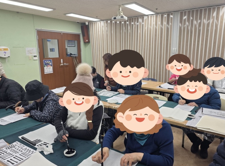 강의실에 모여 앉아 붓과 먹물을 이용해 화지에 선 긋기 연습과 서예를 배우고 있는 수강생들의 모습